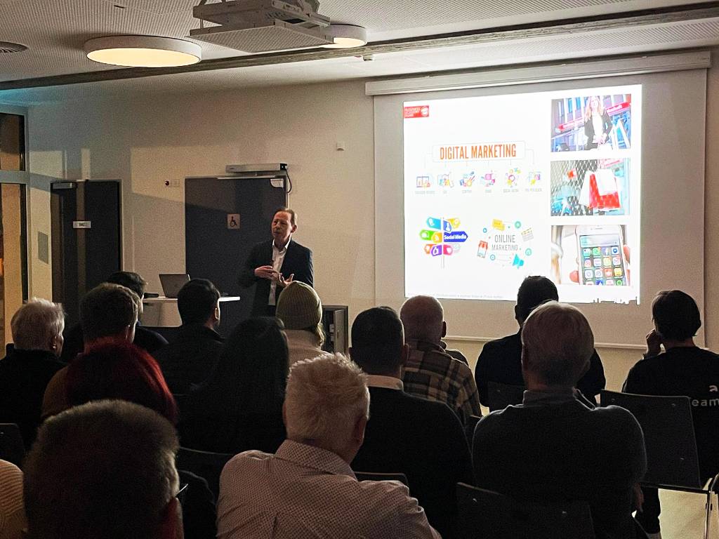 Vortragender und Zuhörer*innen beim IHK-Vortrag im Foyer der Stadthalle