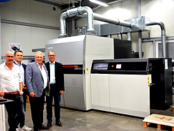 Bürgermeister André Dora lässt sich von Vinzenz, Mark und Jürgen Schmidt bei der Firma Wirtz Druck die neue digitale Druckmaschine erklären.