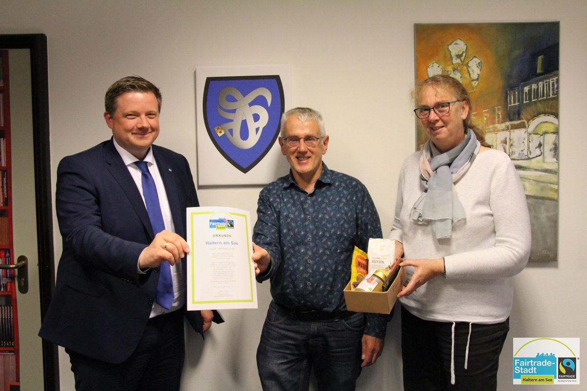 Bürgermeister und Vertreter mit Urkunde in der Hand