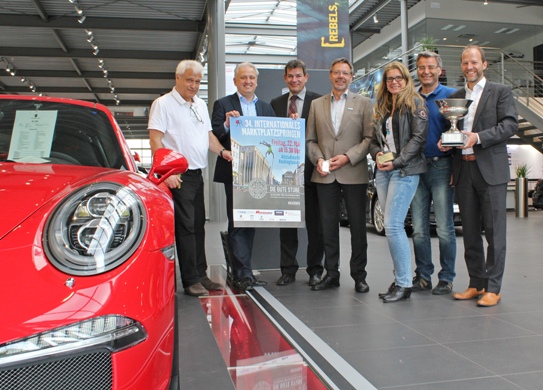Organisator Hans Timmermann (v.l.) stellt gemeinsam mit Guido Twachtmann (Direktor Sparkasse Vest), Carsten Feldhege (MOHAG Automobile), Herbert Bennemann (RWE), Sabine Glose (Sportverwaltung Stadt Recklinghausen), Werner Metz (Abteilungsleiter Sport/Bäder) und Frank Fiegenschuh (Geschäftsführer Porsche Recklinghausen) das Programm zum 34. Marktplatzspringen vor. 