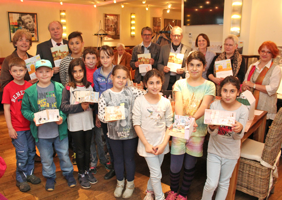Der Erste Beigeordnete Georg Möllers (hinten, 2.v.l.) und Klaus Herrmann (Leiter des Kommunalen Bildungsbüros, hinten, 5.v.r.) stellen gemeinsam mit den beteiligten Projektteilnehmern sowie den Kindern der Gemeinschaftsgrundschule an der Hohenzollernstraße die Projekte zu den Bildungsbausteinen vor.
