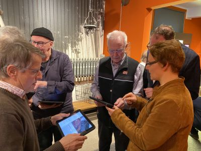 Pressefoto: Dr. Angelika Böttcher (r.) erlebt mit den Bergmännern Rolf Euler (l.) und Dieter Willwerth (Mitte) die Bergbau-Ausstellung der RETRO STATION nochmal ganz neu. Möglich macht es die neu entwickelte AR-App.