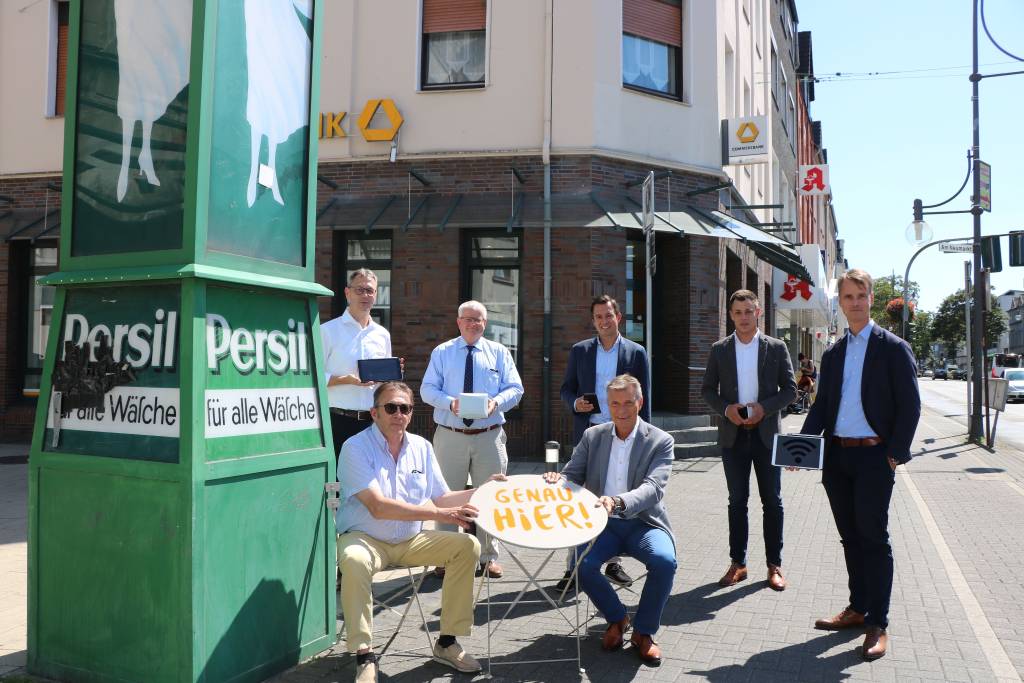 Die neuen Sitzgarnituren und das WLAN-Netz in der Südstadt präsentierten (v. l.) Altstadtmanager Jochen Sandkühler, Wolfgang Dramsch (Vors. „Genau Hier! Südstadt RE e.V.“), Erster Beigeordneter Ekkehard Grunwald, Christoph Kuchenreuther (The Cloud), Bürgermeister Christoph Tesche, Mario Urmitzer (The Cloud) und Georg Gabriel (Abteilungsleiter Stadtmarketing). Foto: Stadt RE