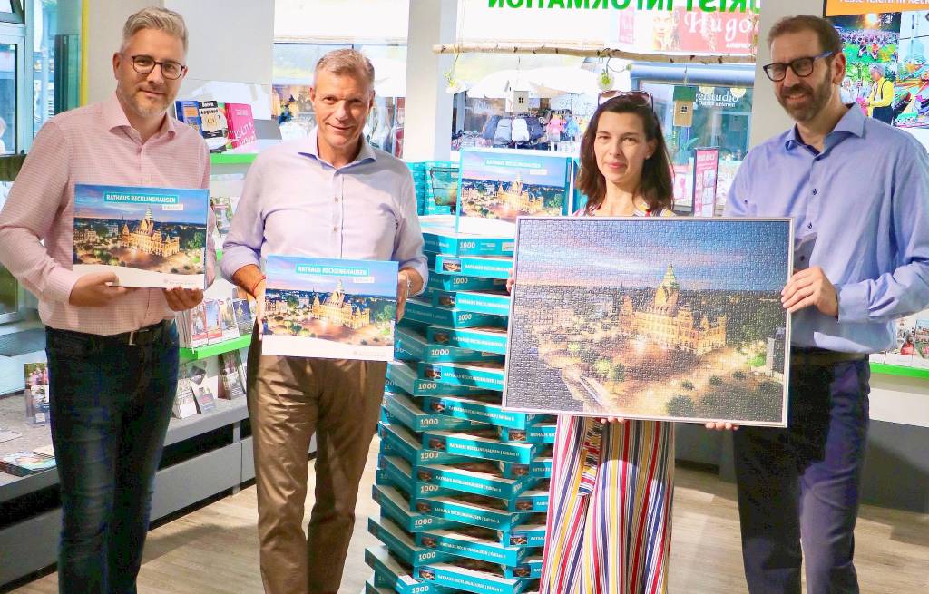 Bürgermeister Christoph Tesche (2.v.l.) ist genauso begeistert von der zweiten Edition des Rathaus-Puzzles wie Hendrik Eßers, Fachbereichsleiter Wirtschaftsförderung, Standortmanagement, Stadtmarketing (l.), Christina Guth und Tim Rimprecht (beide Tourist Information). Foto: Stadt RE