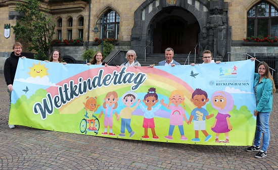 Gruppenfoto mit Plakat der Veranstalter