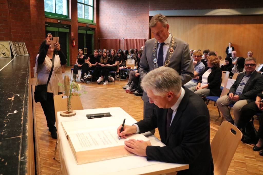 Ludwig Theodor Heuss tr&auml;gt sich in das Goldene Buch der Stadt Recklinghausen ein, das B&uuml;rgermeister Christoph Tesche anl&auml;sslich des Theodor-Heuss-Tags ins B&uuml;rgerhaus S&uuml;d mitgebracht hatte. Foto: Stadt RE