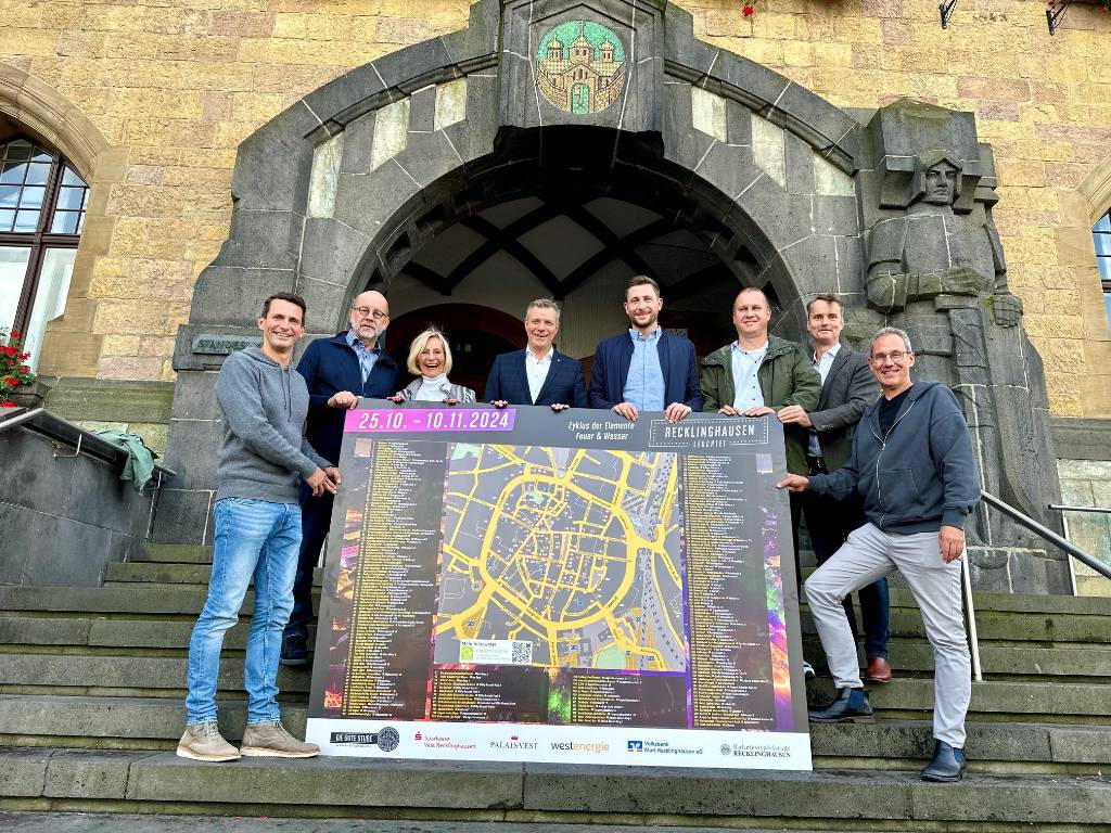 Auf der Treppe des schönsten Rathauses von NRW stellten sie den Plan für „Recklinghausen leuchtet 2024“ vor (v.l.): Marius Ebel (Arena RE GmbH), Heinz Waschhof, Hannelore Kemper (beide Stadtführer*innen), Bürgermeister Christoph Tesche, Markus Droste (Westenergie), Marc Schäper (Regiofreizeit/Kreis RE), Georg Gabriel (Abteilungsleiter Stadtmarketing) und Lars Tottmann (Arena RE GmbH). Foto: Stadt RE
