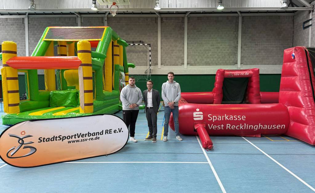 Daniel Gohrke (r.) und Philip Berg (SSV RE) präsentieren zusammen mit Christian Schmidt (Mitte Sparkasse Vest) das Erlebnisland. Foto: Stadt RE