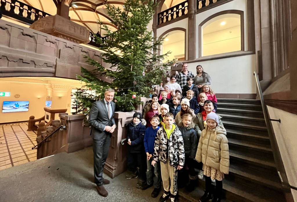 Bürgermeister Christoph Tesche schmückte zusammen mit den OGS-Kindern der Gudrun-Pausewang-Schule und den Erzieherinnen Stefanie Walters und Sherin Salvarcioglu den großen Baum im Rathaus-Foyer. Foto: Stadt RE