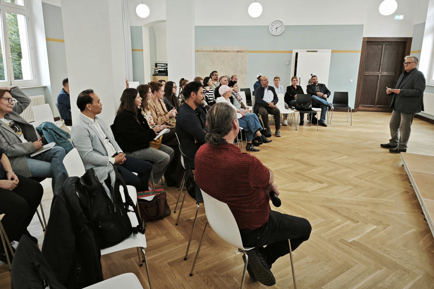 Klaus Herrmann, Leiter des Instituts „Die Brücke“, begrüßt die Besucher*innen der Informationsveranstaltung zur Integrationsratswahl im Willy-Brandt-Haus. Foto: Stadt RE