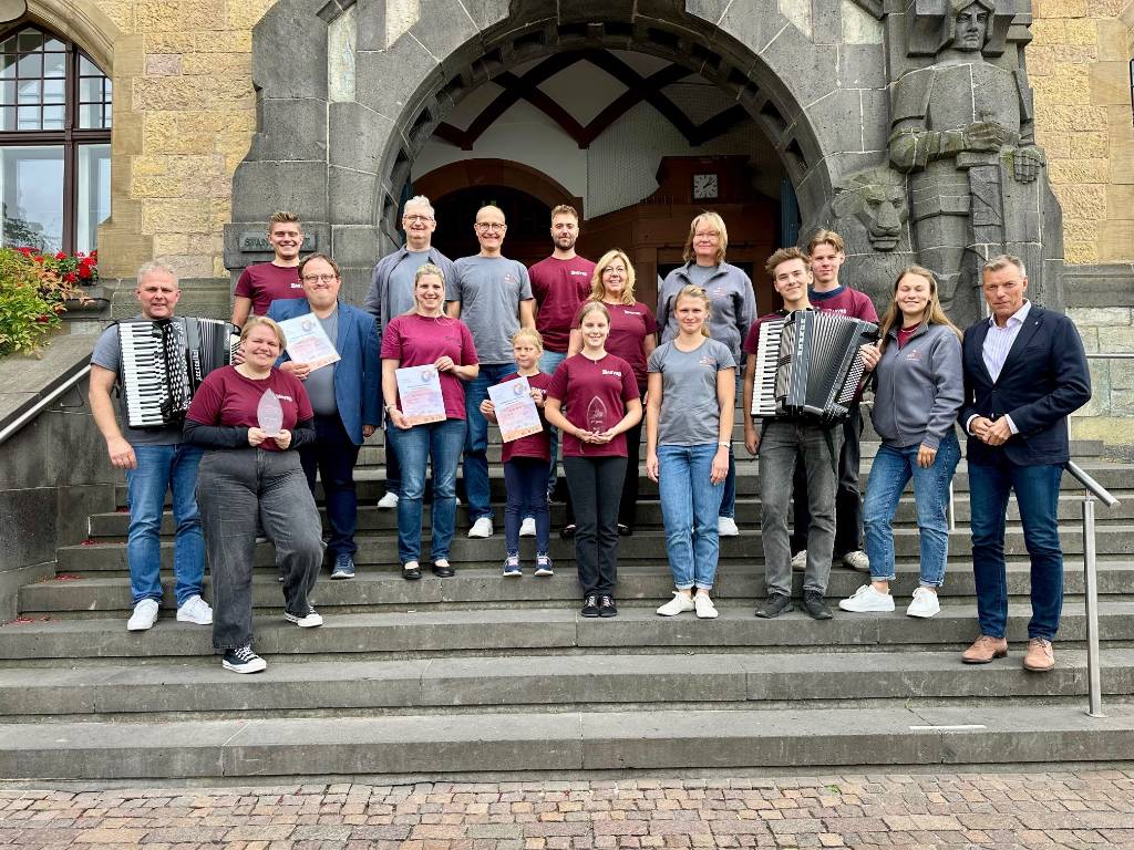 Auf der Rathaustreppe präsentierten die Akkordeonorchester beim Treffen mit Bürgermeister Christoph Tesche die in Innsbruck errungenen Auszeichnungen. Foto: Stadt RE