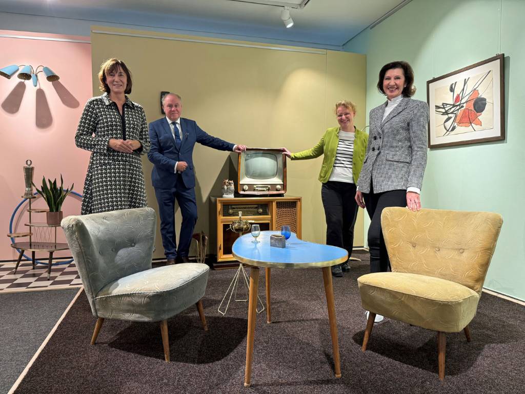Barbara Ruhnau, Dr. Matthias Kordes und Dr. Angelika Böttcher vom Institut für Stadtgeschichte und die stellvertretende Bürgermeisterin Marita Bergmaier (v. li.) in einem Wohnzimmer im Stile der Wirtschaftswunderjahre.