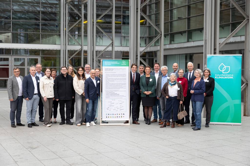 Setzen sich für klimaresiliente Gewerbegebiete in der Emscher-Lippe-Region ein: Dezernent*innen und Vertreter*innen aus Kommunen der Zukunftsinitiative Klima.Werk mit den Vorständen von Emschergenossenschaft/Lippeverband: Prof. Dr. Uli Paetzel, Liana Weissmüller (Mitte rechts neben dem Banner) und Dr. Frank Obenaus (3.v.re.).