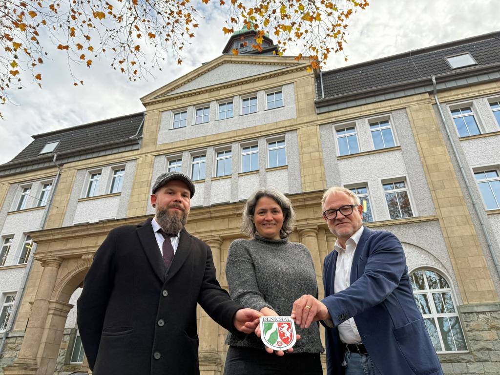 Schulleiter Jörg Schürmann erhielt eine Urkunde und die Denkmal-Plakette für sein Gymnasium aus den Händen der Technischen Beigeordneten Christina Kutschaty und Sascha Müller von der Bauordnung - Untere Denkmalbehörde. 