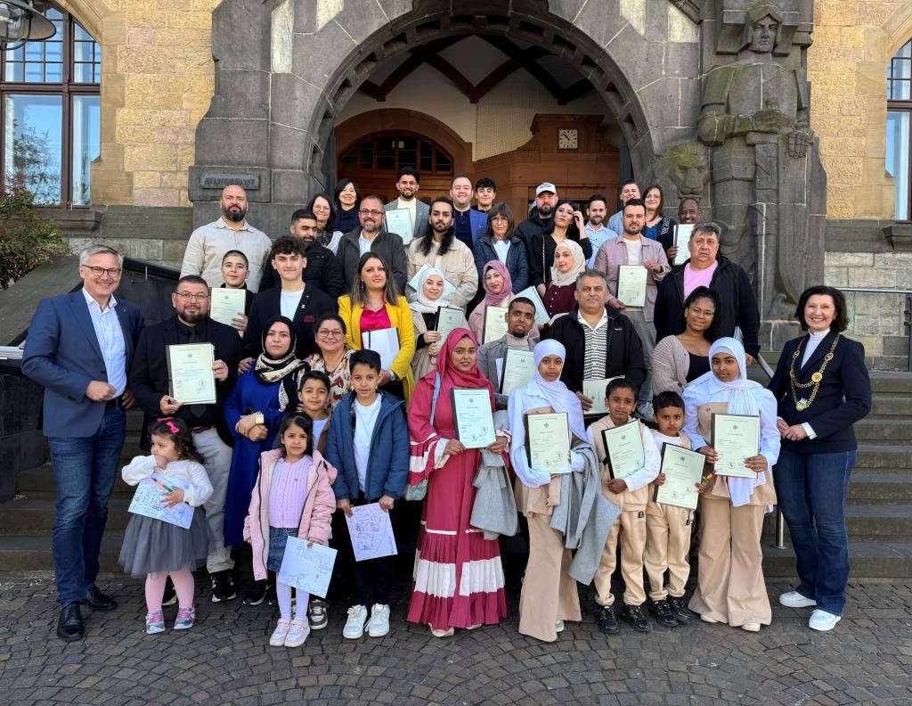 B&uuml;rgermeister Axel Tschersich und stellvertretende B&uuml;rgermeisterin Marita Bergmaier auf der Rathaustreppe mit den Eingeb&uuml;rgerten