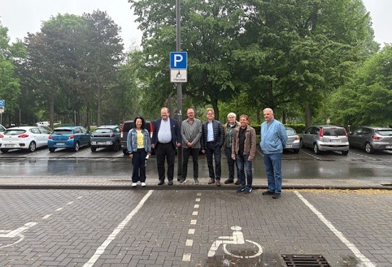 Barbara Ehnert, Referentin f&uuml;r Behindertenangelegenheiten, Sozialdezernent Dr. Sebastian Sanders sowie Heiko Elert, Achim Kruner, Susann Rasche, J&ouml;rg Berger und Frank Petri (v.li.) von beteiligten Fachbereichen stehen an Behindertenparkpl&auml;tzen zwischen Rathaus und Erlbruchpark