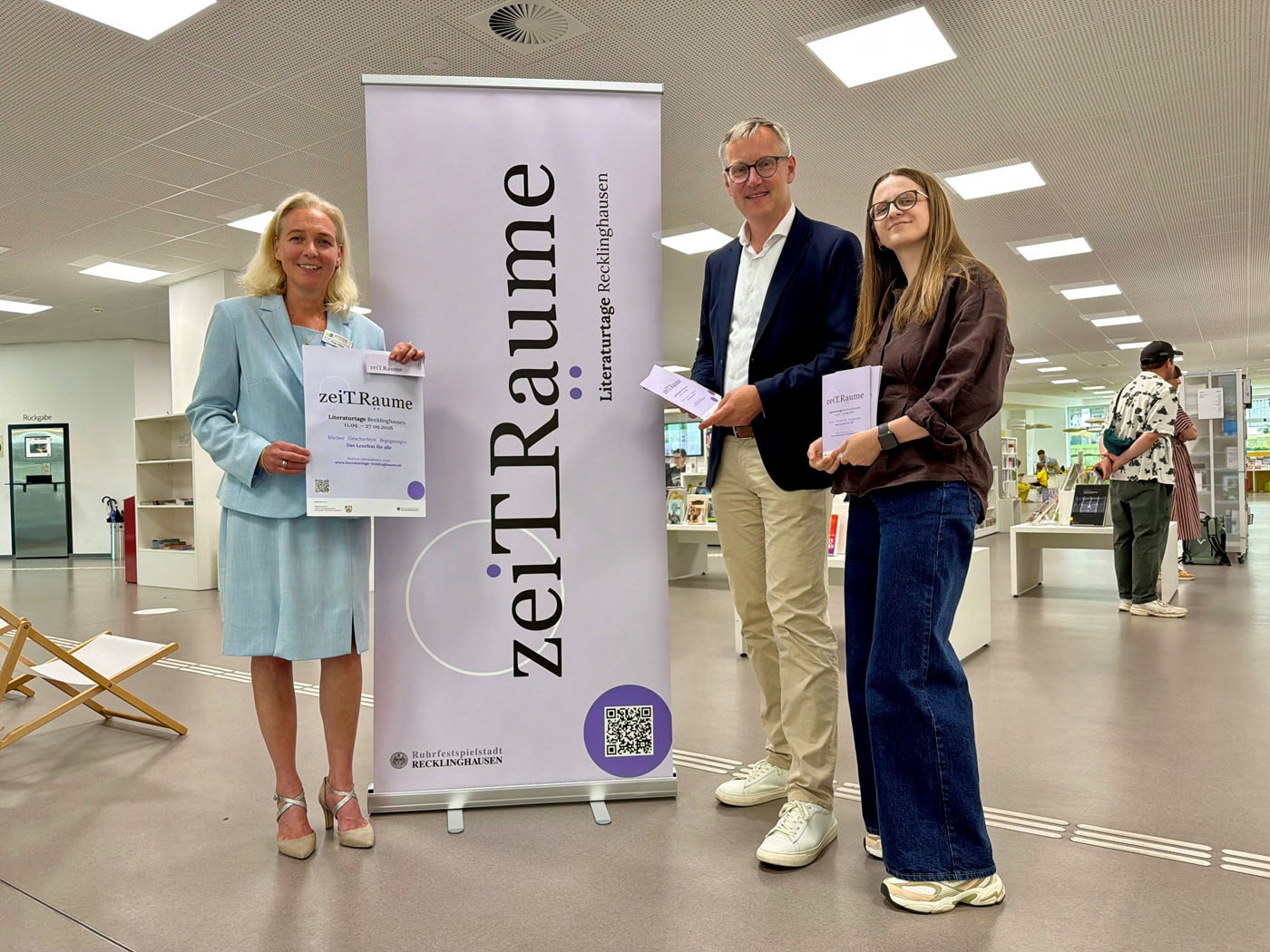Bibliotheksleiterin Sandra Hilse, B&uuml;rgermeister Axel Tschersich und Kulturplanerin Celine St&ouml;ckle (v. li.) laden ein zu den Literaturtagen 2026. Der Kartenvorverkauf startet am Freitag, 10. Juli. Foto: Stadt RE