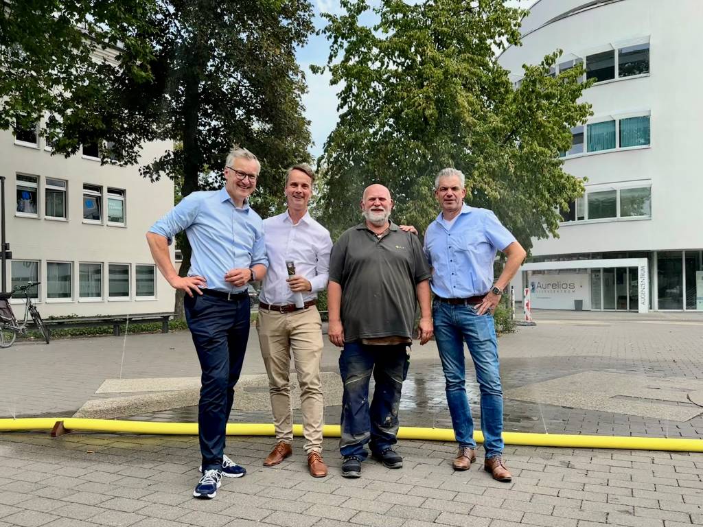 Bürgermeister und Kollegen vor dem Wasserschlauch