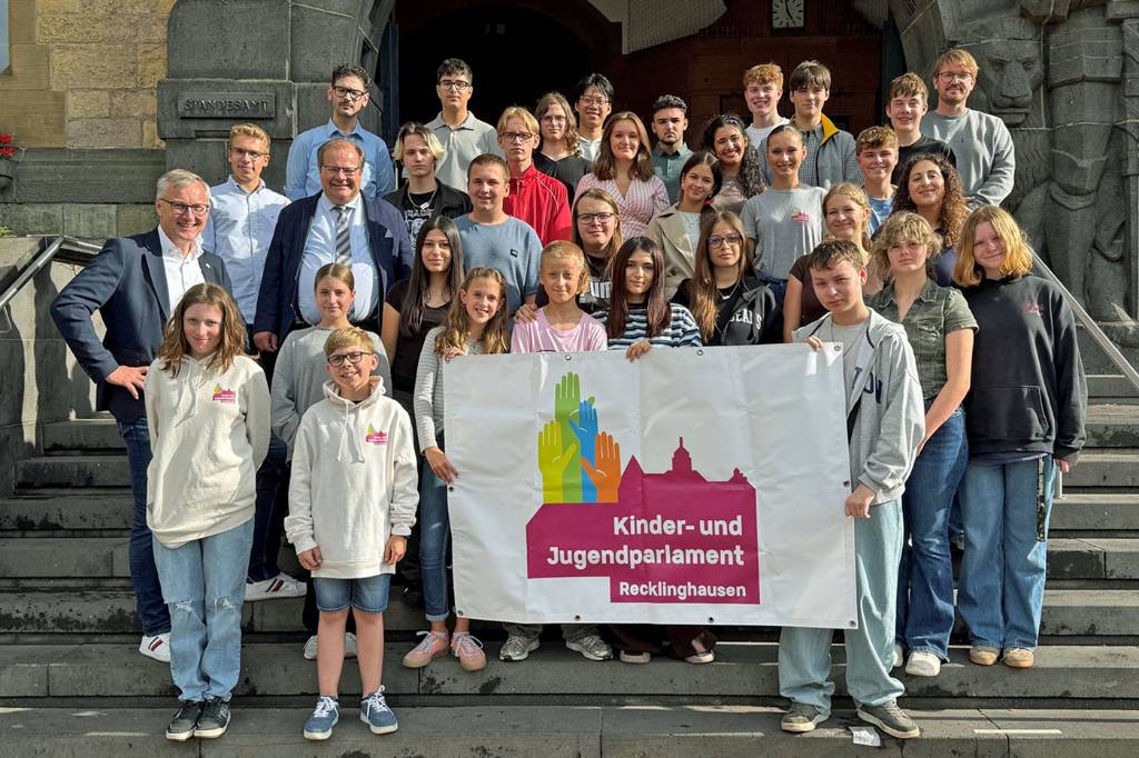 Die Teilnehmer*innen der ersten Vollversammlung des 12. Kinder- und Jugendparlaments der Stadt Recklinghausen auf der Treppe zum Rathaus-Haupteingang.