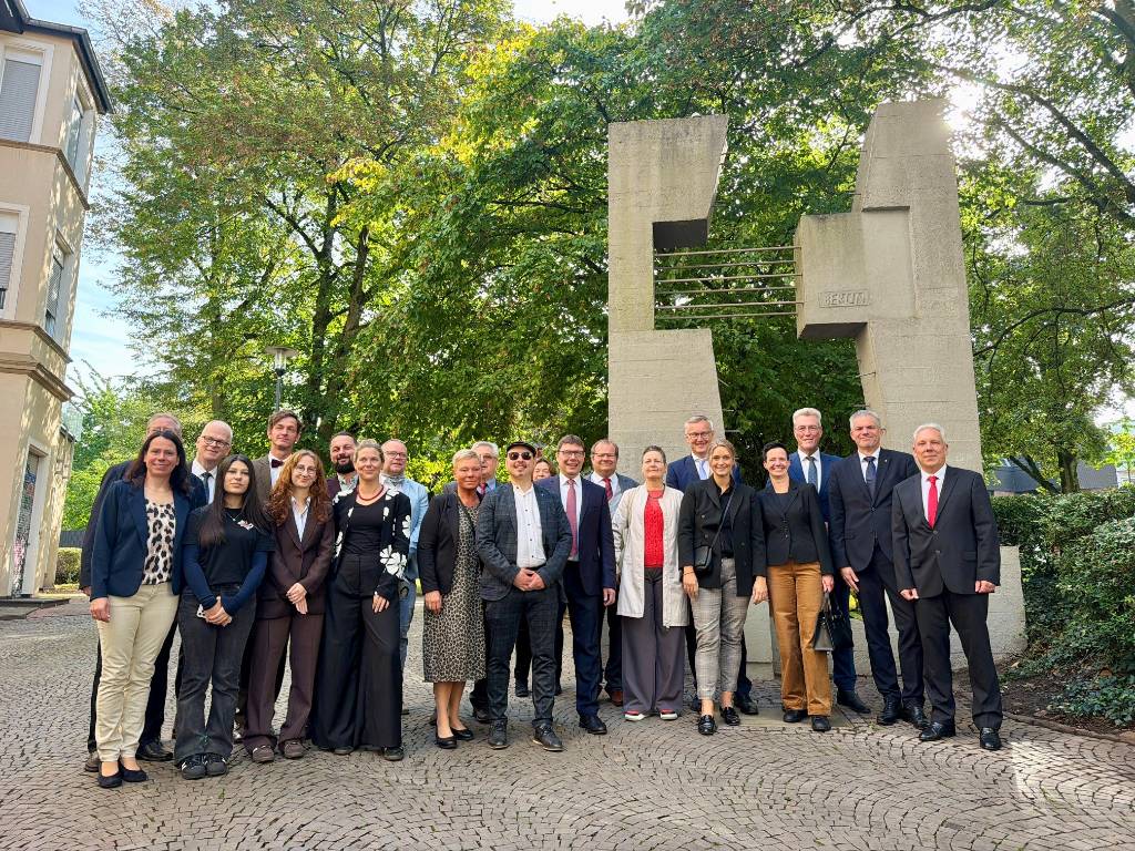 Am Denkmal &bdquo;Ungeteiltes Deutschland&ldquo; im Schatten der Propsteikirche St. Peter legten die B&uuml;rgermeister Axel Tschersich und Thomas Kaminski Blumen nieder. Die Delegation aus Schmalkalden stellte sich mit heimischen Vertreter*innen aus Politik und Verwaltung zum Erinnerungsfoto auf. Fotos (2): Stadt RE